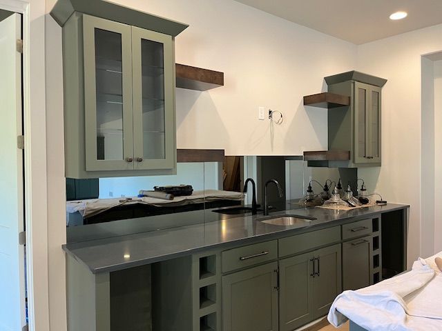 A kitchen with a sink, cabinets, and counter tops.