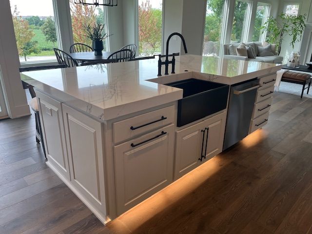 A kitchen with white cabinets and a black sink