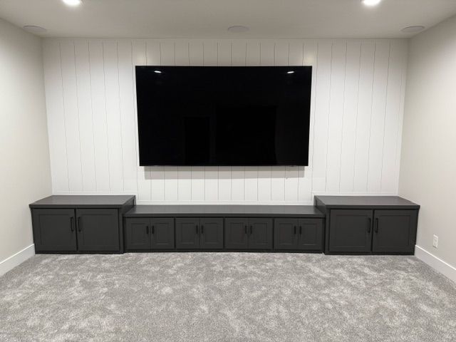 A home theater with a flat screen TV mounted on the wall.