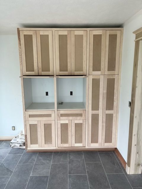A room with a lot of wooden cabinets and drawers