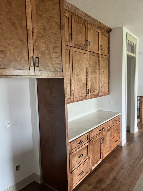 A kitchen with wooden cabinets and white counter tops