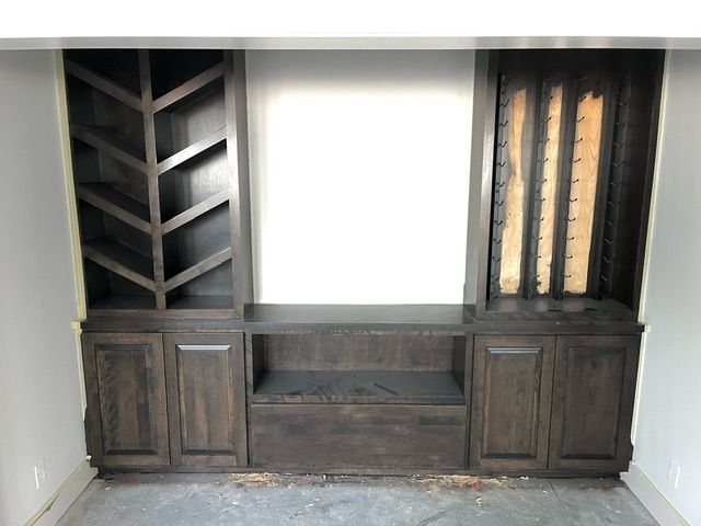 A room with wooden cabinets and a wine rack