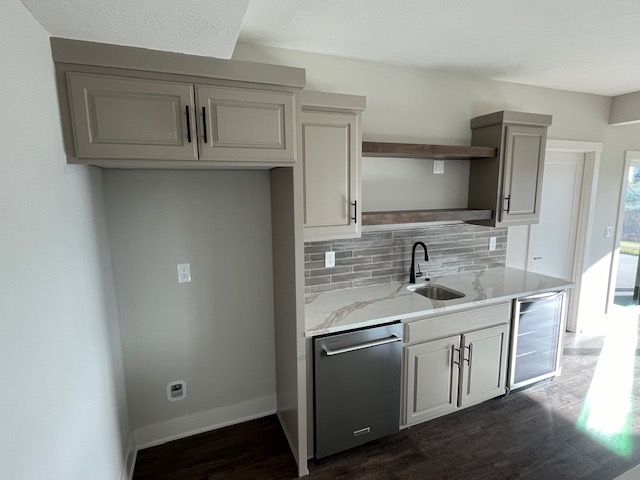 A kitchen with a sink , dishwasher and refrigerator.