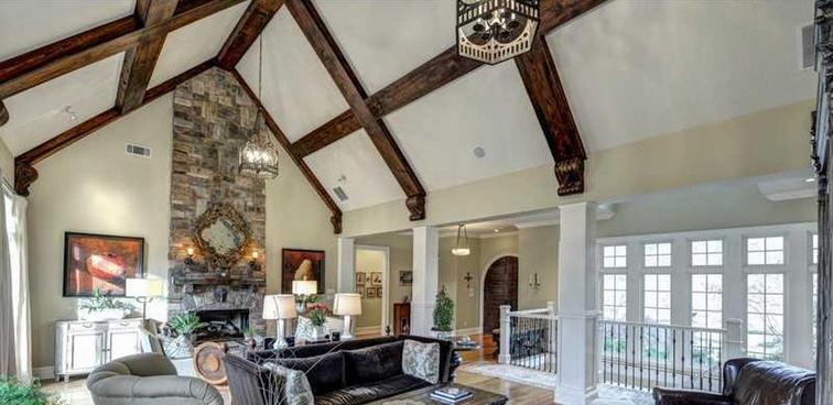 A living room with a vaulted ceiling and a fireplace.