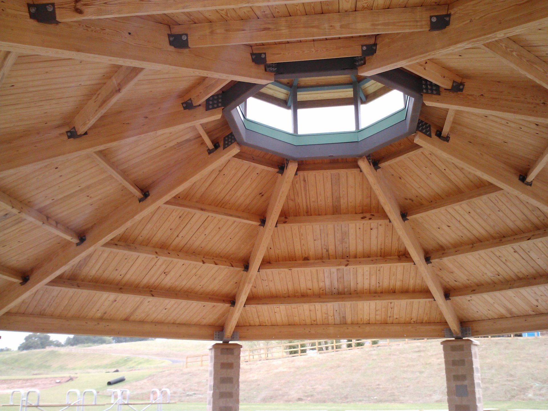 A wooden gazebo with a dome in the middle