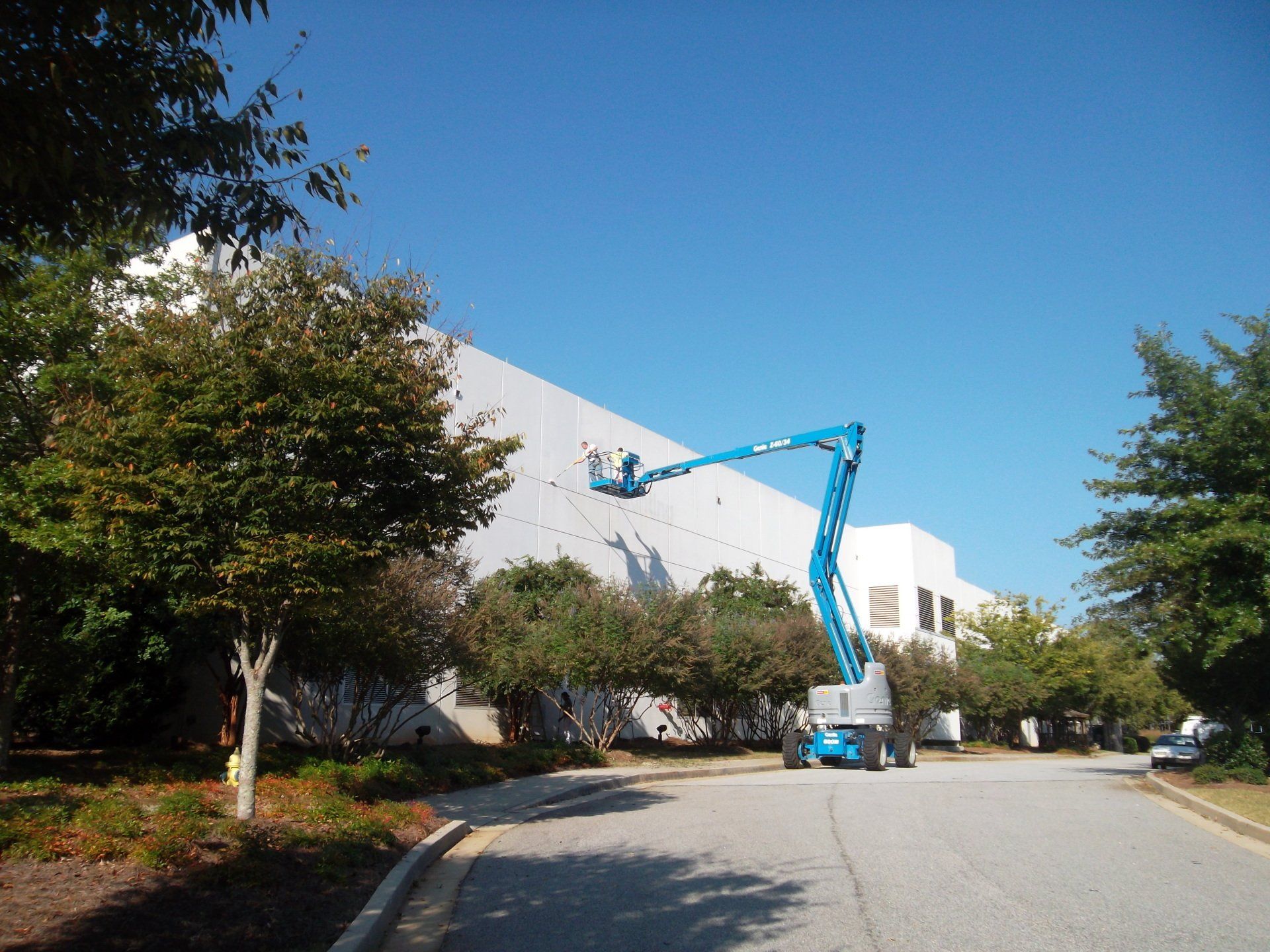 A large white building with a blue crane in front of it