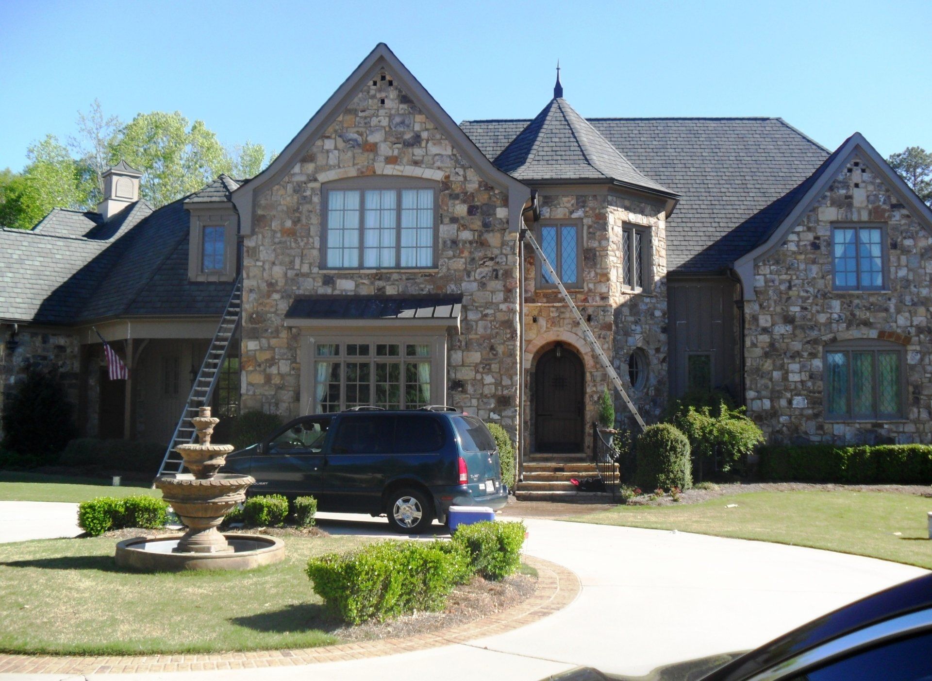 A large stone house with a car parked in front of it