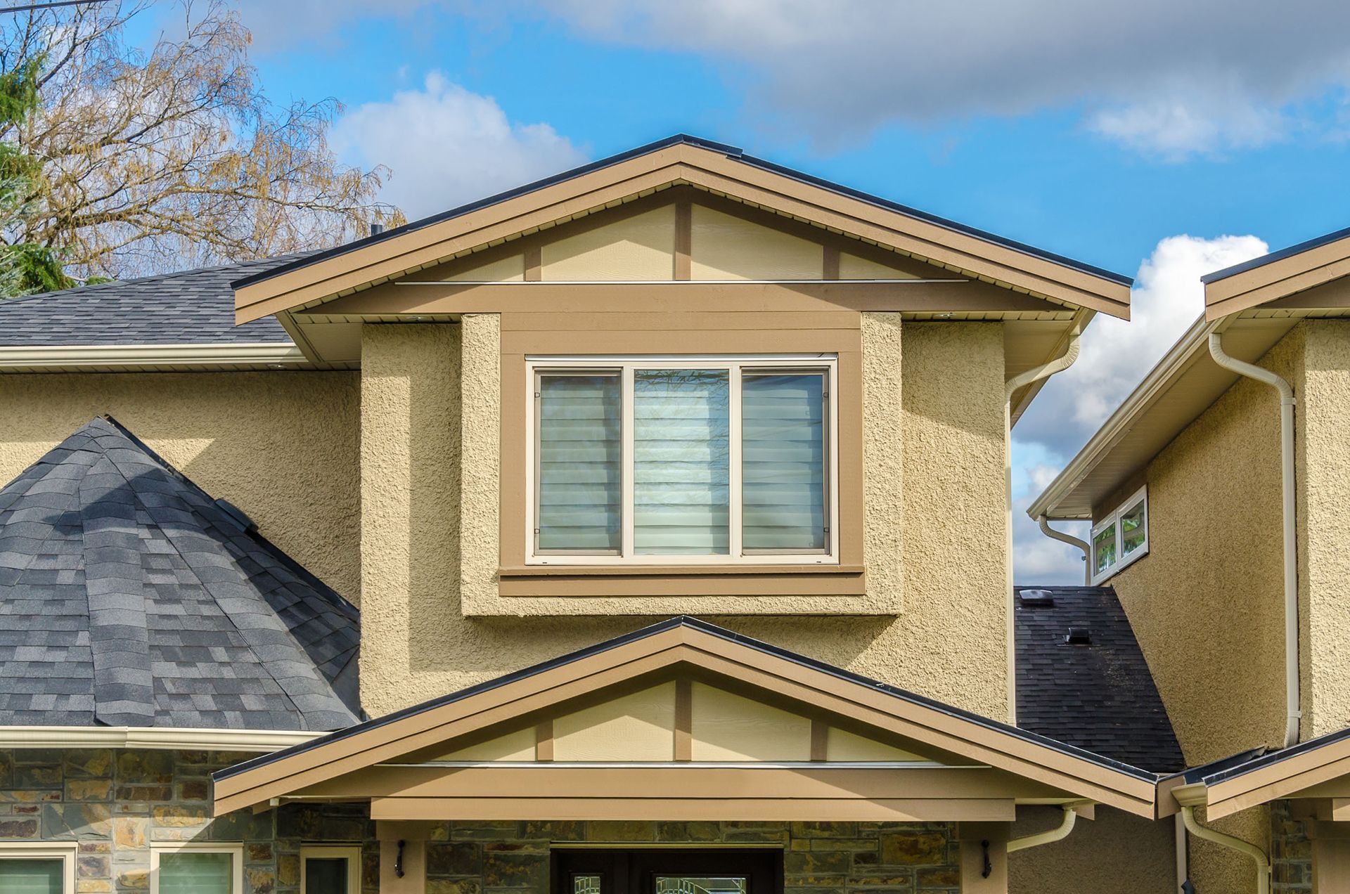 The front of a house with a large window and a roof