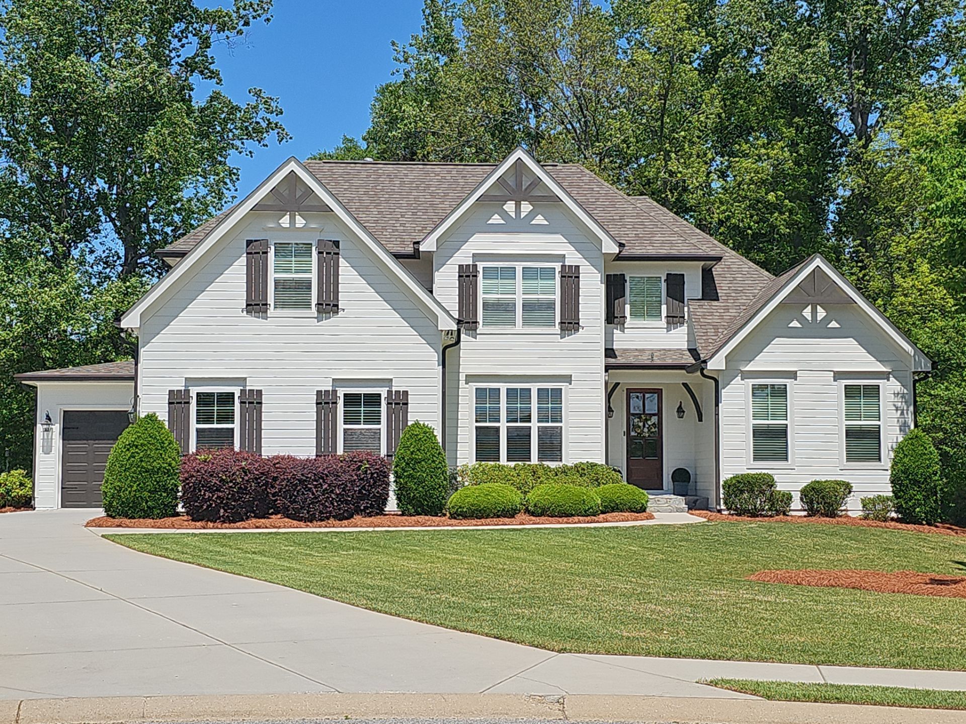 A large house with a lot of windows and shutters on a cloudy day.