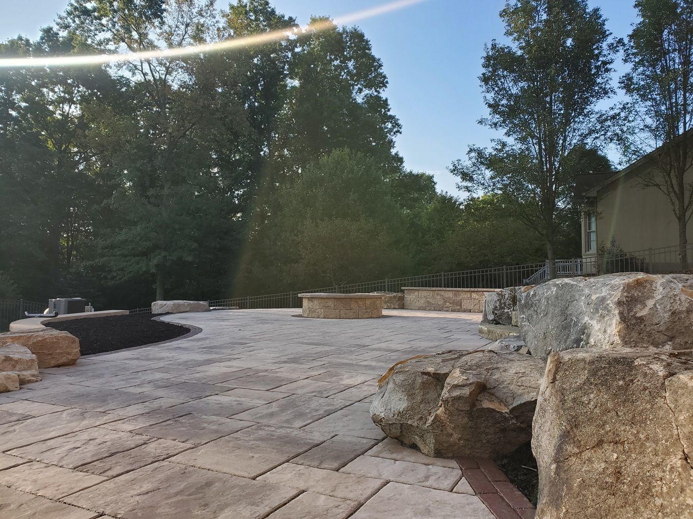 A patio with rocks and trees in the background