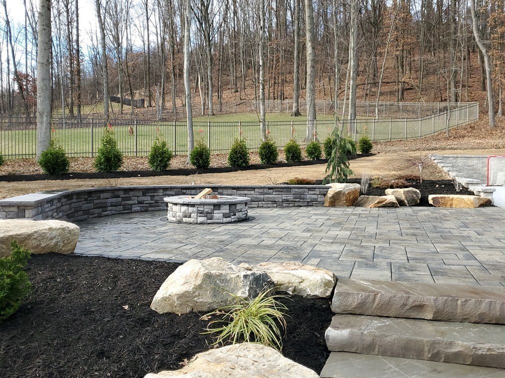 A patio with a fire pit in the middle of it