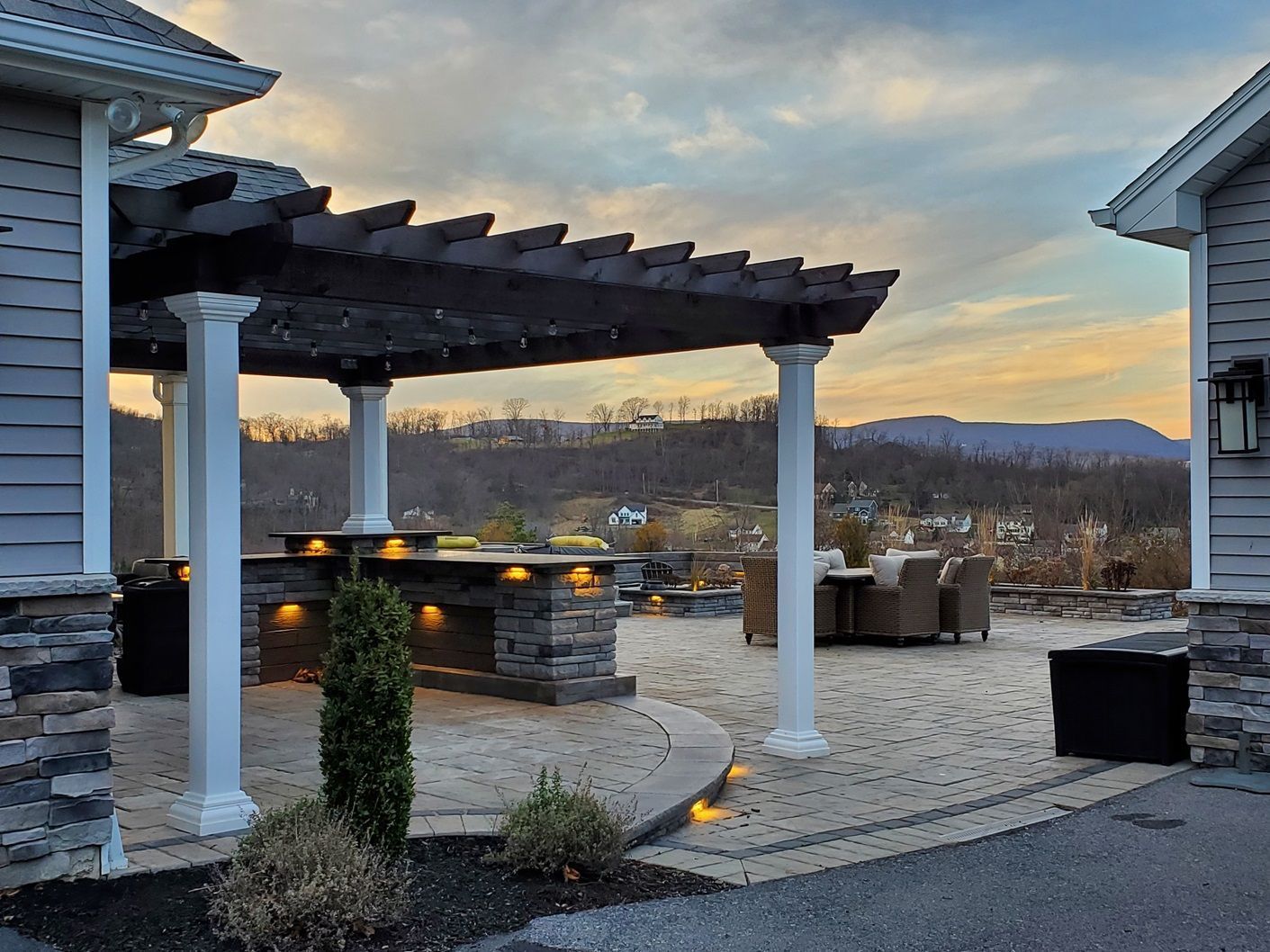 A house with a pergola and a patio in front of it.