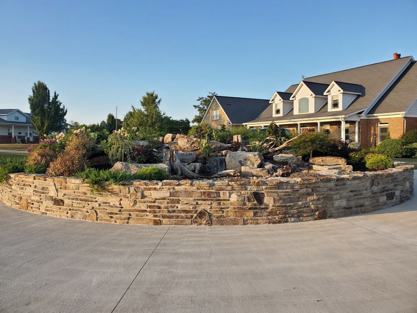 A large house with a stone wall in front of it