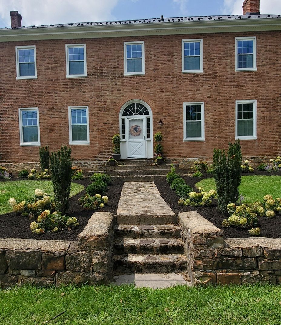 A large brick house with a stone walkway leading to the front door.