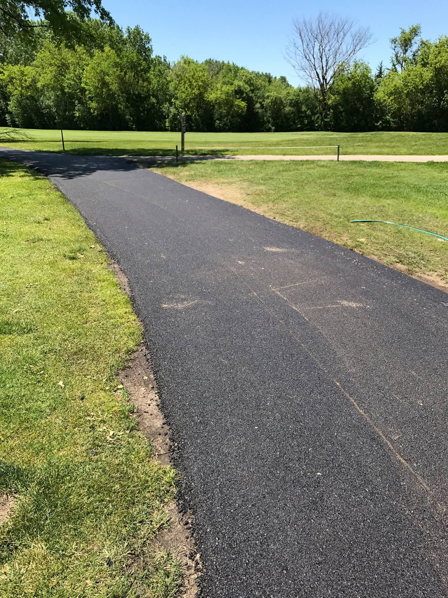 A path going through a grassy field in a park.