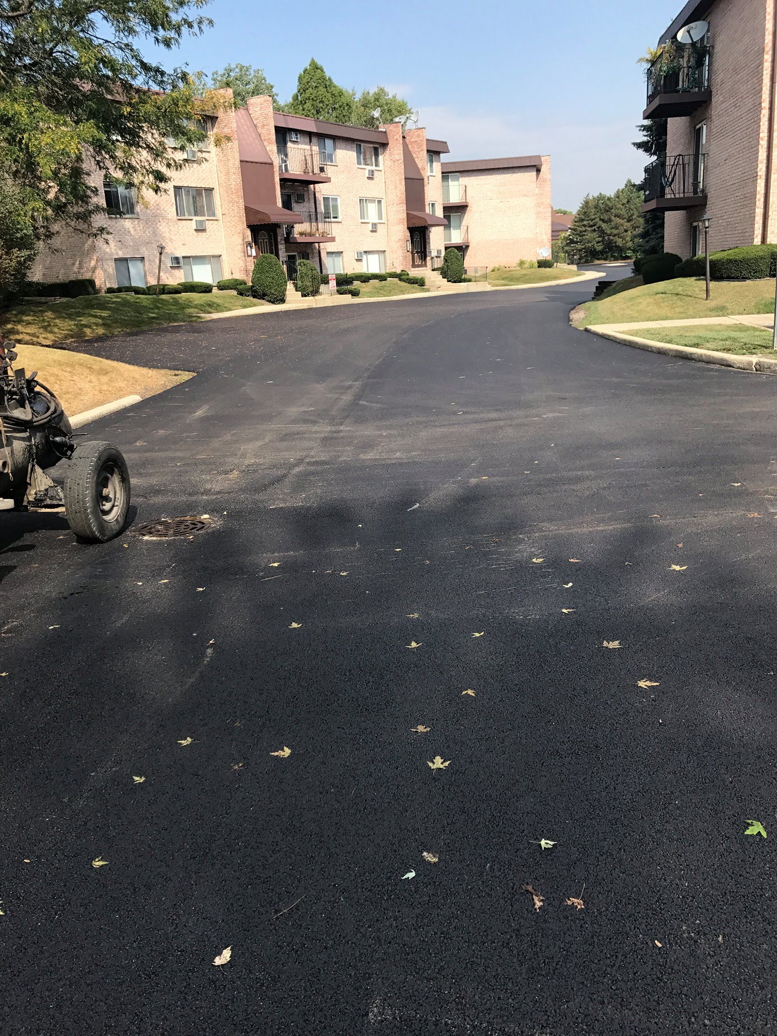 A tractor is parked on the side of a road in front of a building.