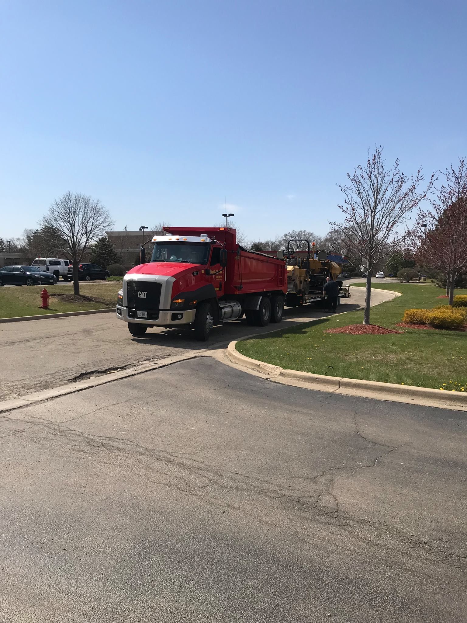 A red dump truck is parked on the side of the road.