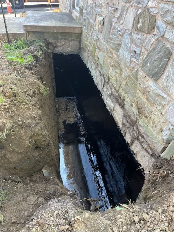 A hole in a stone wall with water coming out of it.