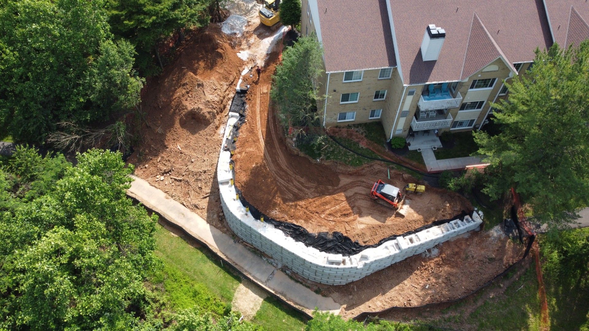 An aerial view of a construction site with a building in the background.