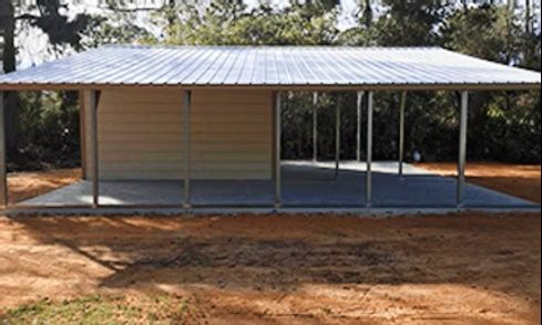Metal-roofed pavilion with open sides on a dirt lot in a rural setting