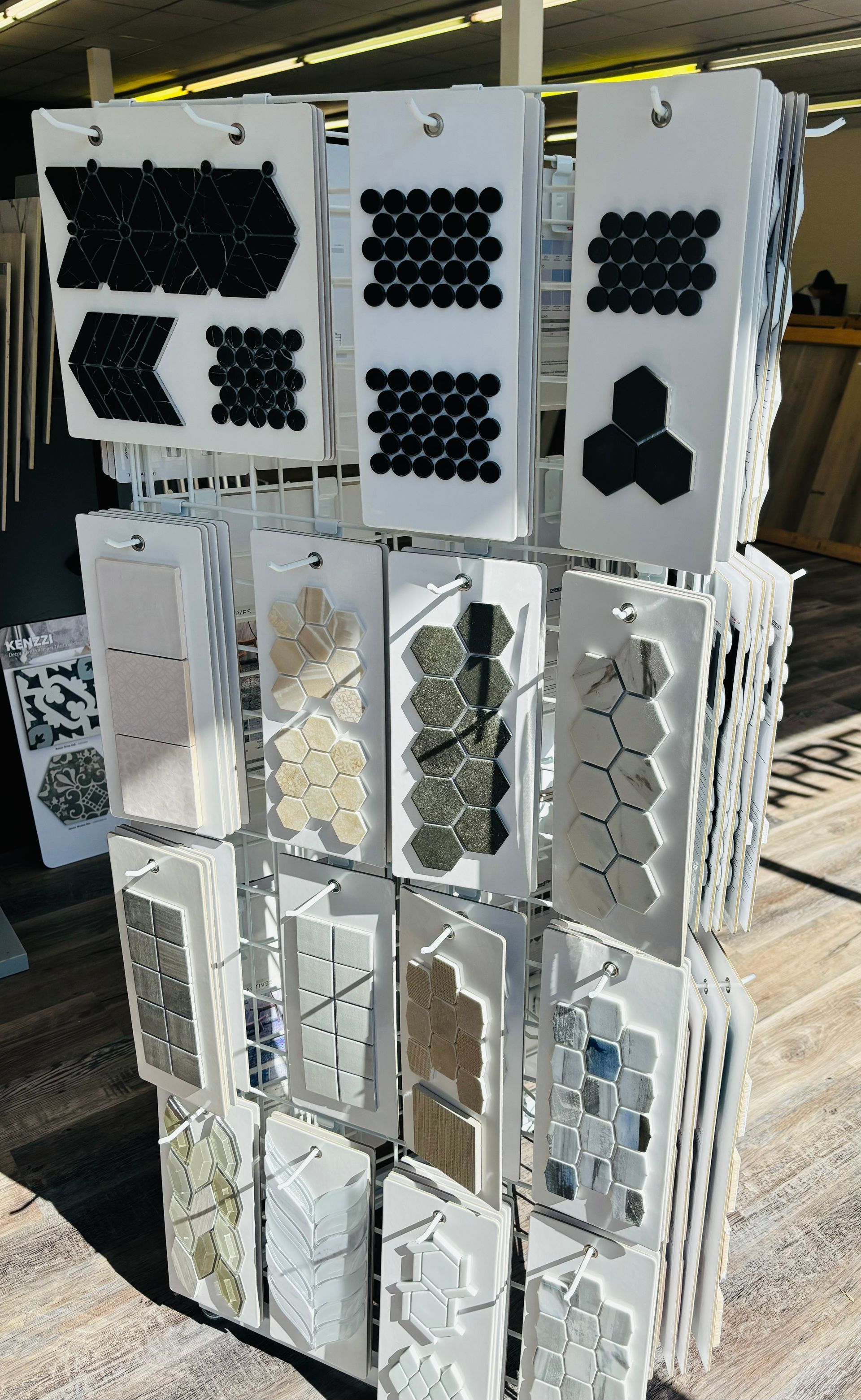 A display of tiles is sitting on a wooden floor in a store.