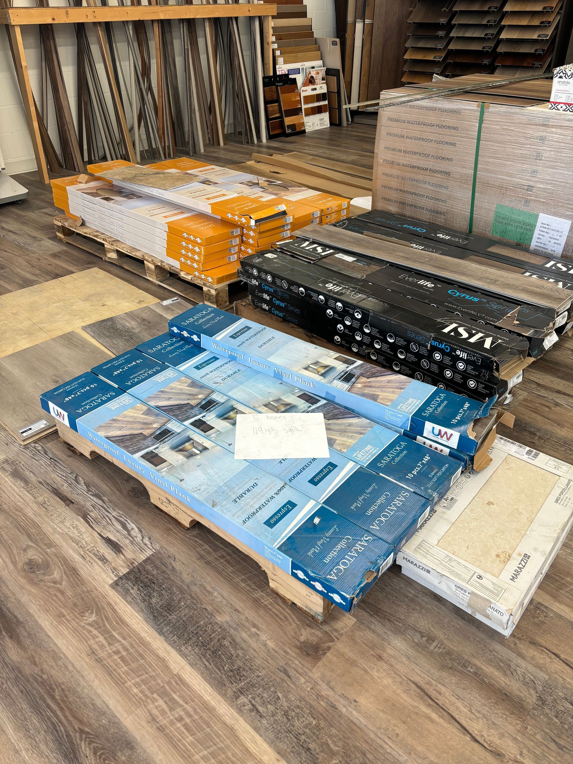 A pallet of wooden flooring is sitting on top of a wooden floor.
