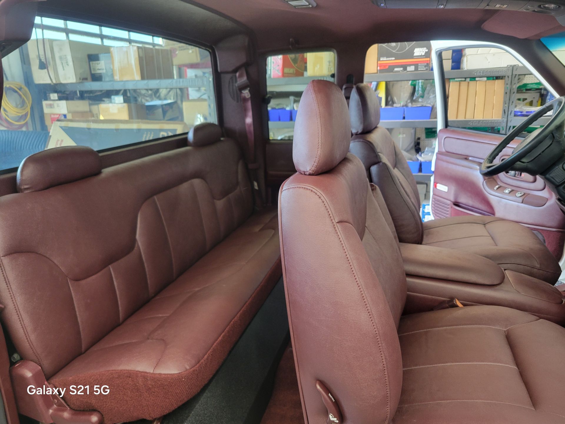 Interior of a tan minivan with rear bench and front seats, shown from the back