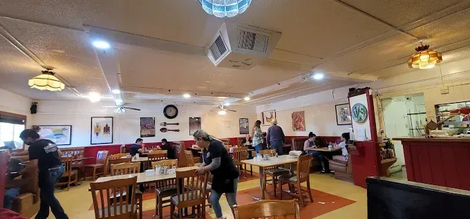 A restaurant filled with people sitting at tables and chairs.