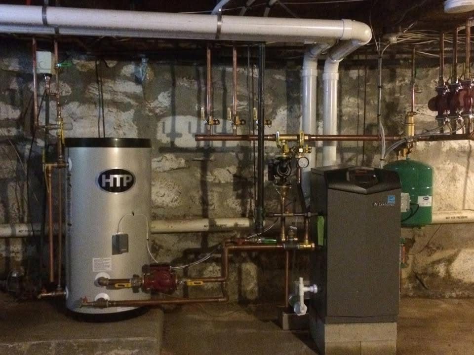 A htp water heater is sitting in a basement