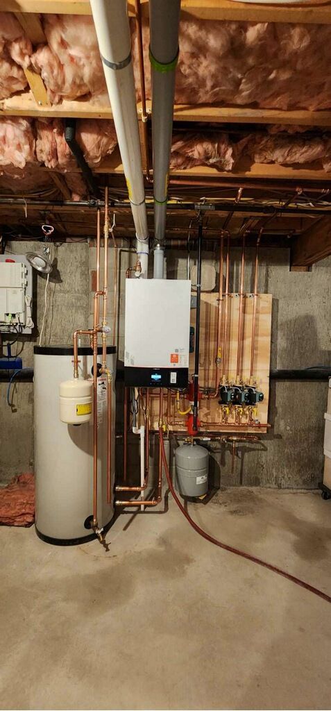 A basement with a water heater and a boiler.