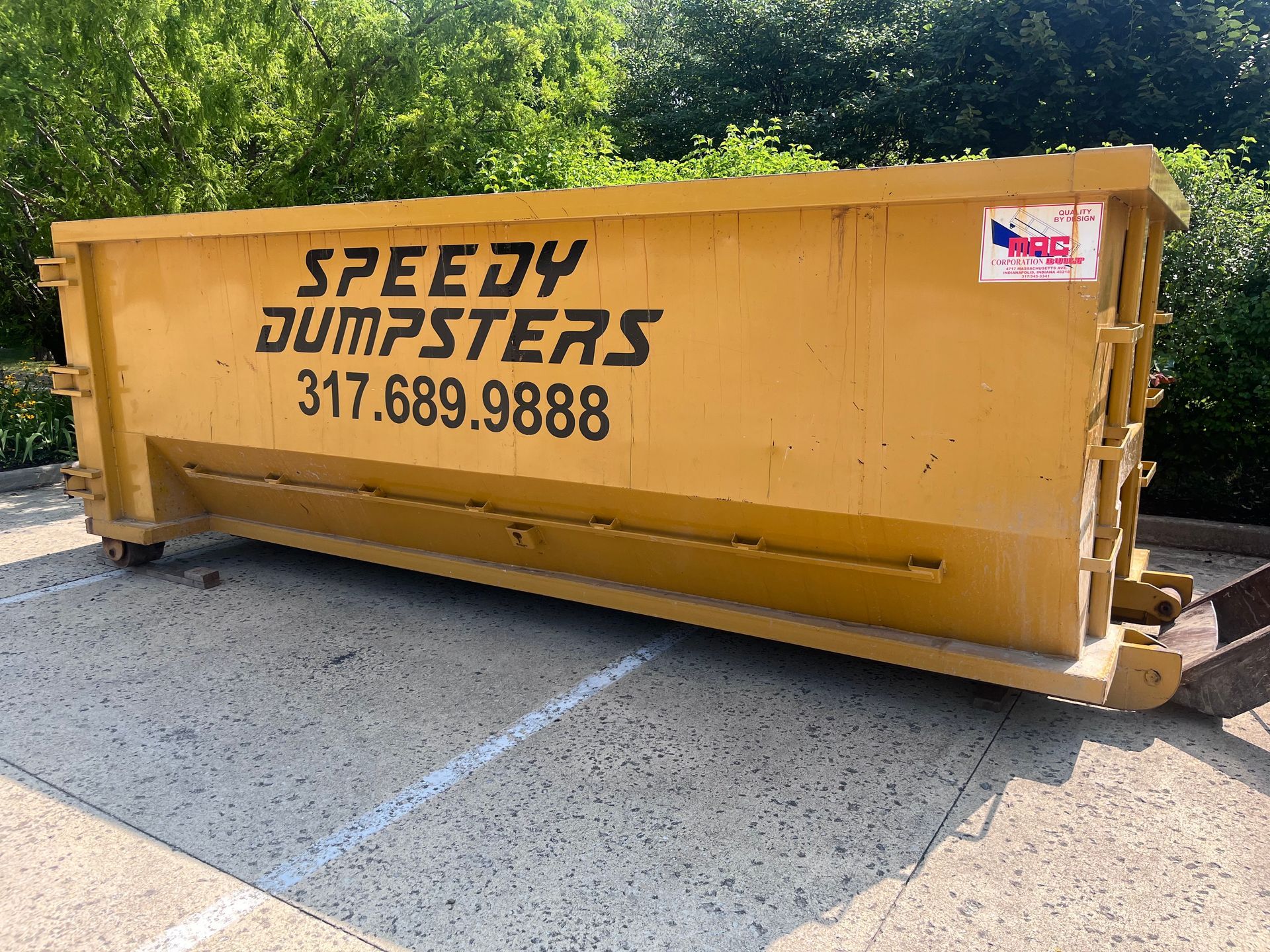 Yellow Speedy Dumpsters dumpster; phone number 317.689.9888; parked outside.