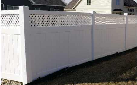 White vinyl fence with lattice top in a residential yard.