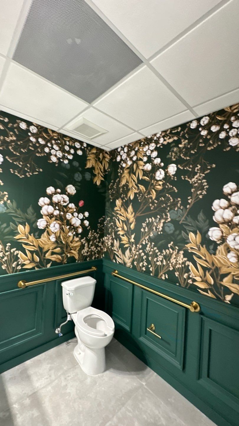 A bathroom with two toilets and a floral wallpaper on the walls.