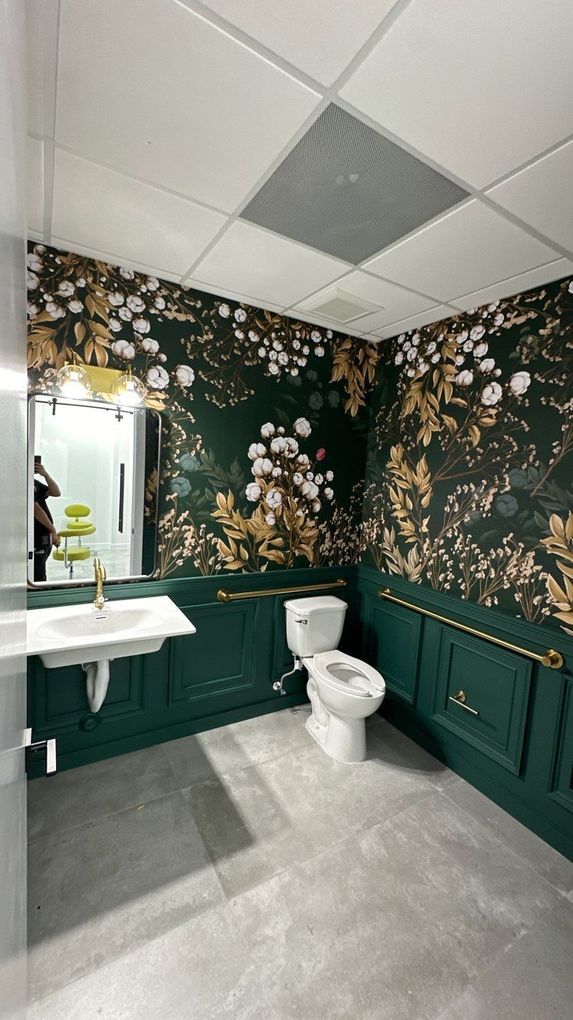 A bathroom with a toilet , sink and mirror.