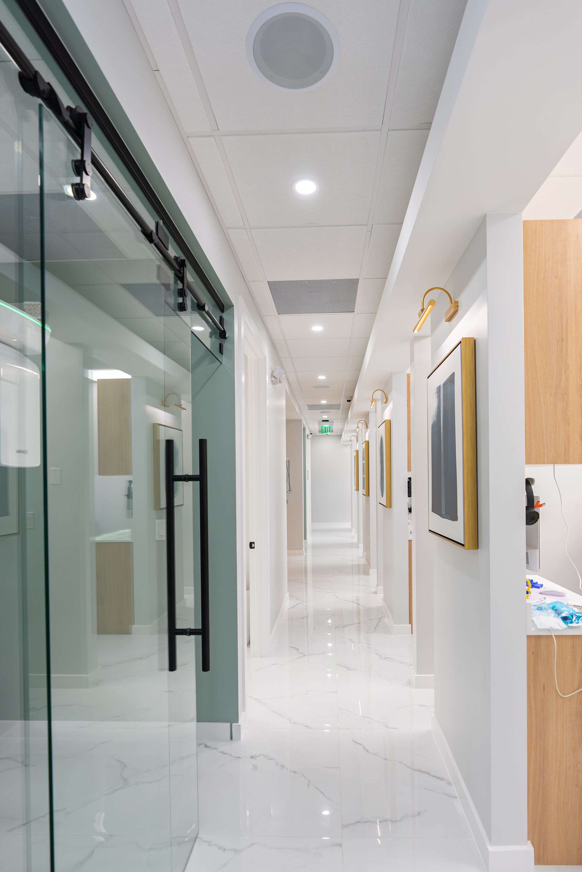 A long hallway in a dental office with sliding glass doors.