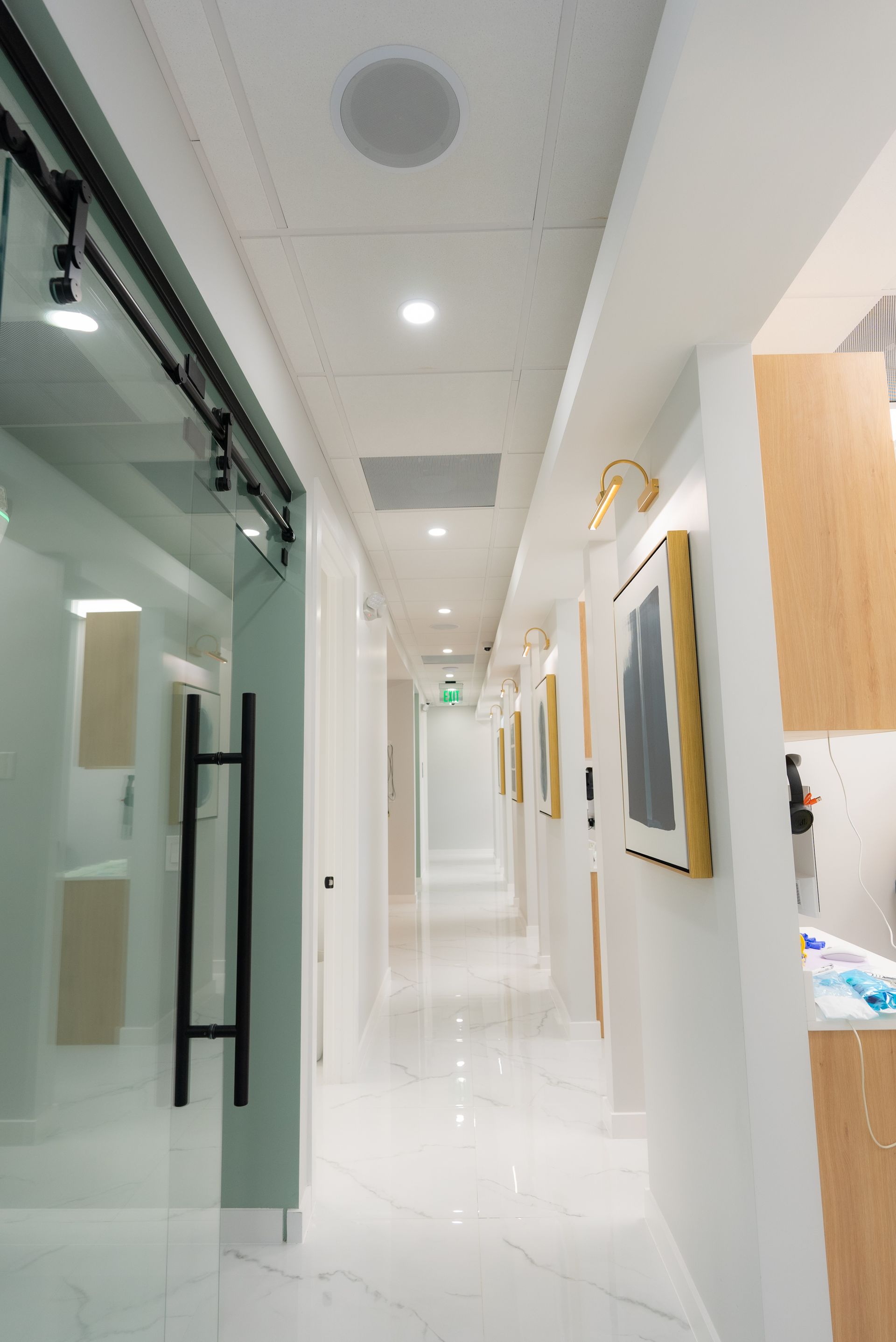 A long hallway in a dental office with a sliding glass door.