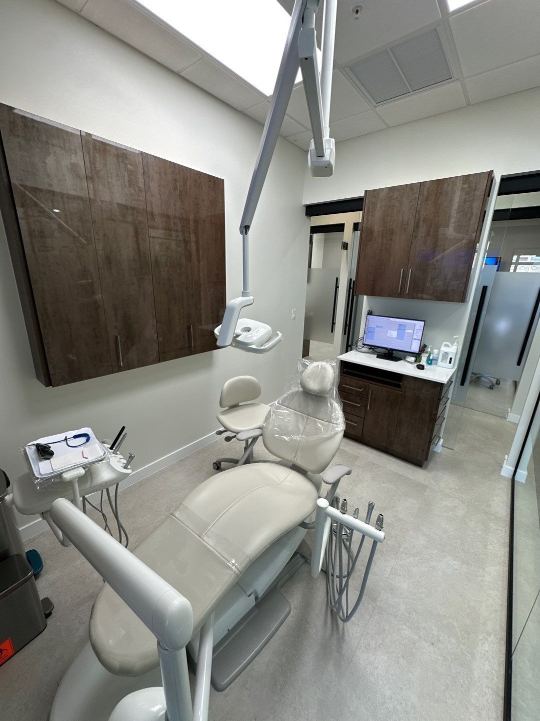 A dental office with a dental chair and a computer.