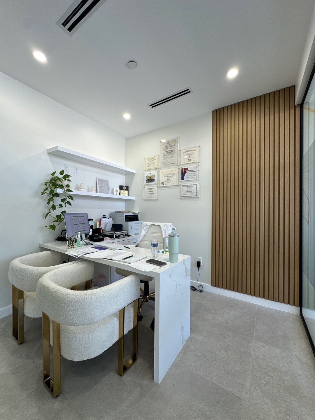 A room with a desk and two chairs in it.