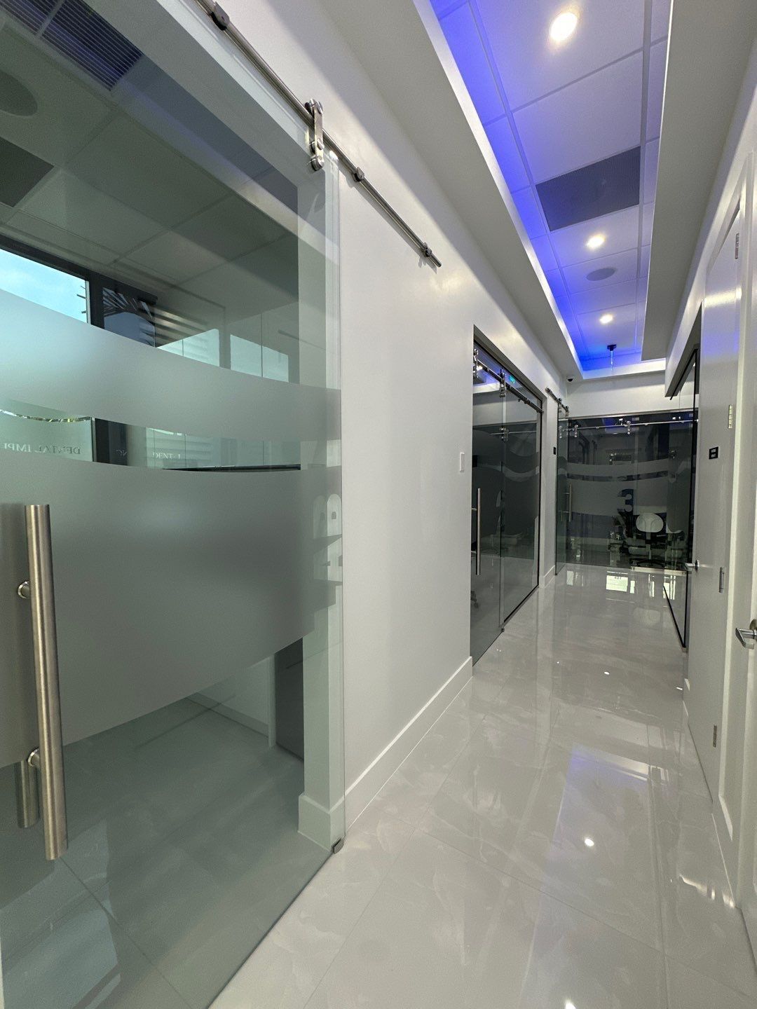 A long hallway with sliding glass doors and a blue ceiling