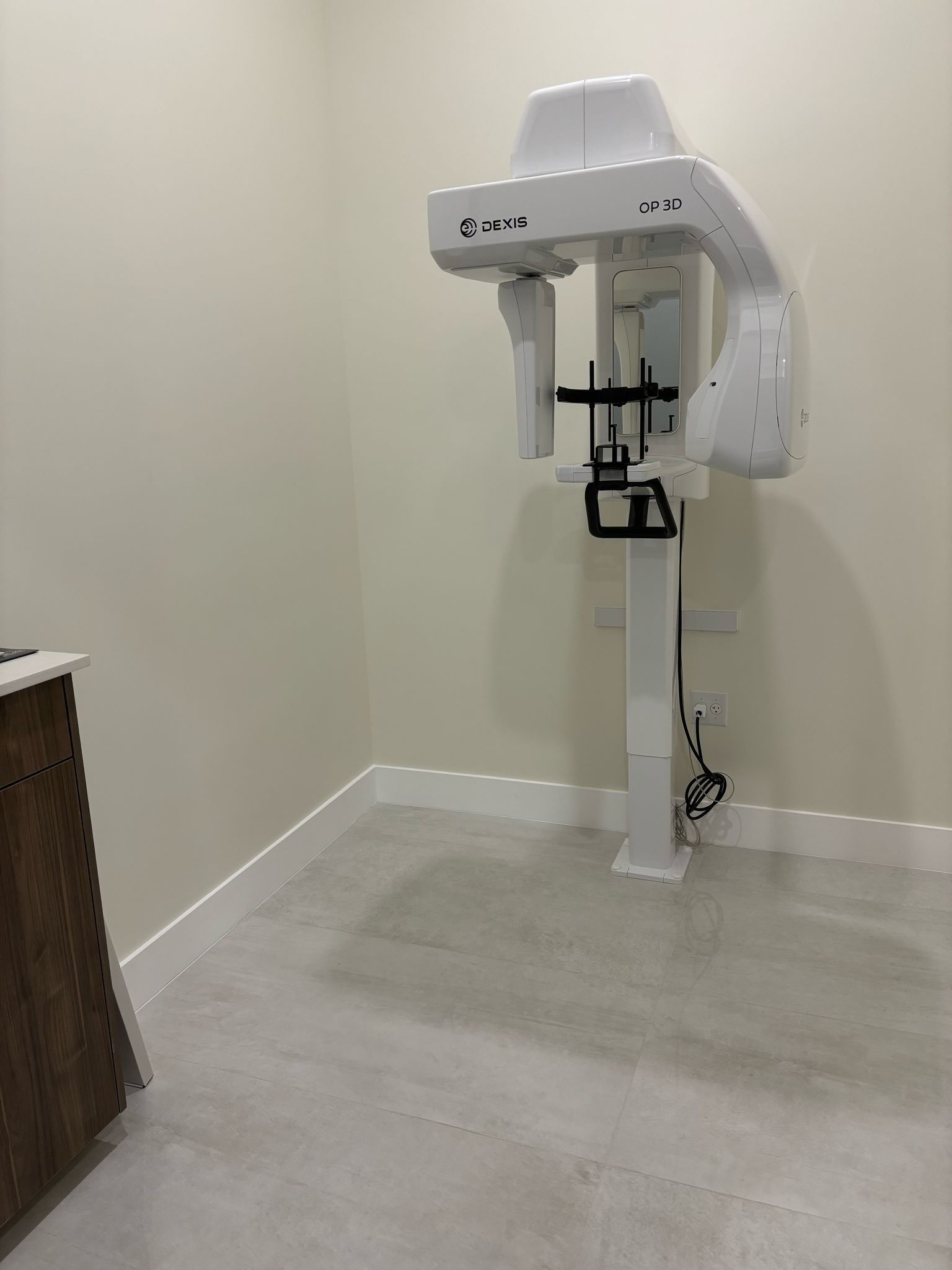 A room with a dental x-ray machine on the wall.