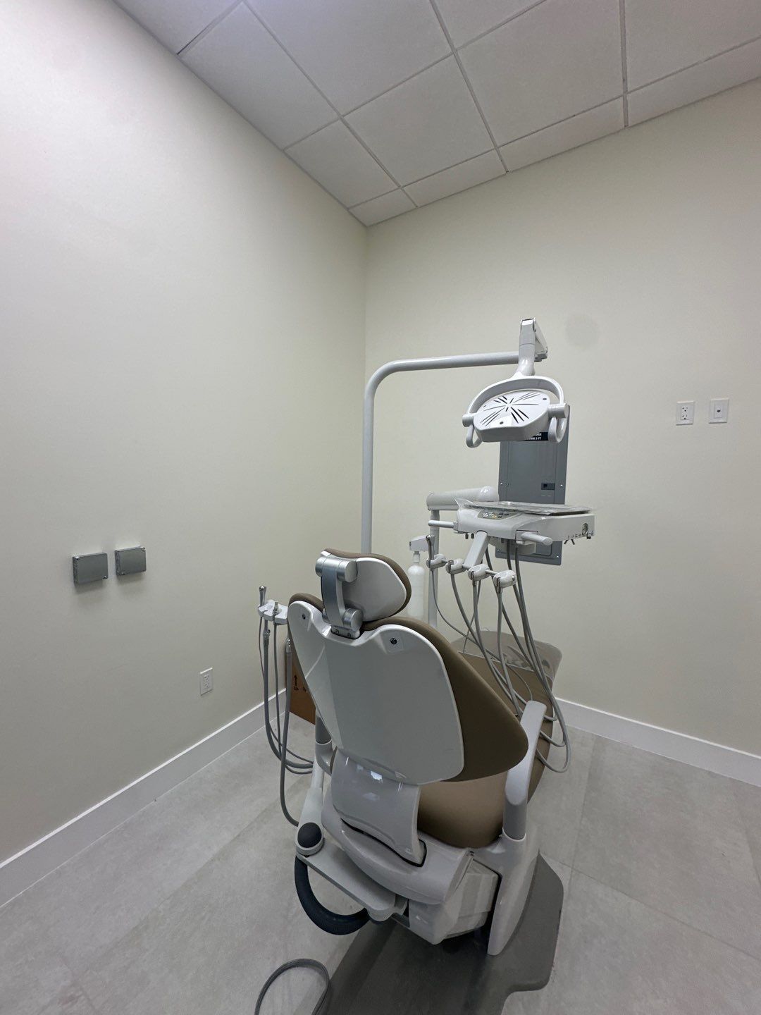 A dental chair is sitting in a dental office.