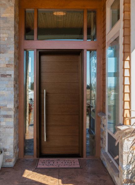 A wooden door with a welcome mat in front of it