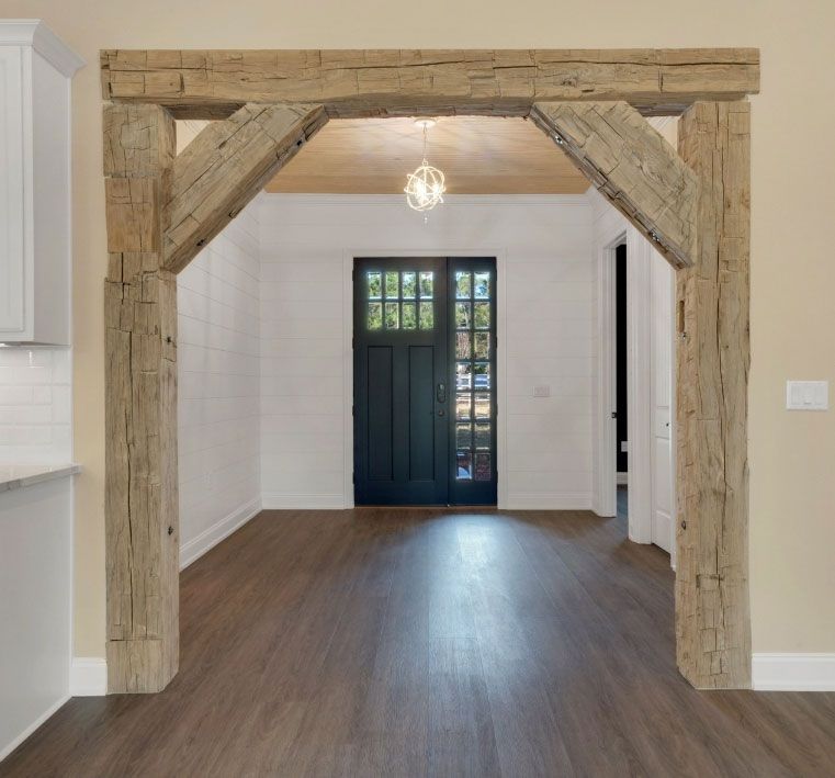 A hallway with wooden beams and a black door