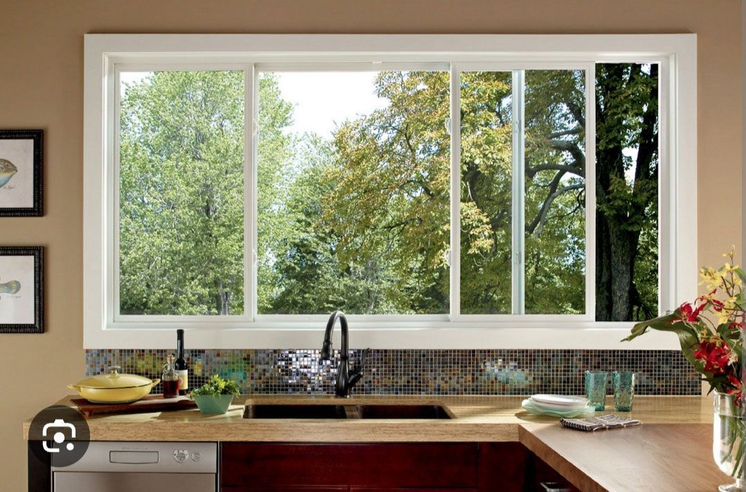 A kitchen with a large window over the sink.
