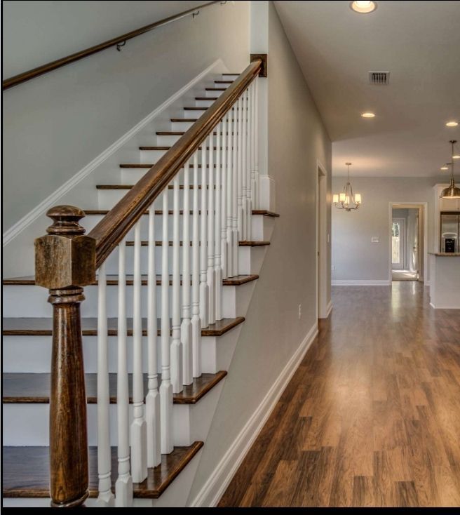 A staircase with a wooden railing in a hallway