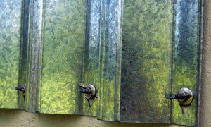 A close up of a row of metal shutters on a wall.