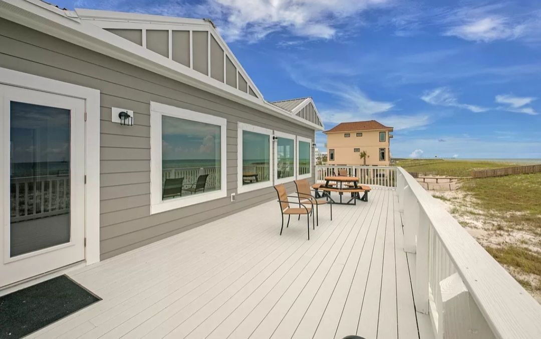 There is a large deck with a table and chairs on it.