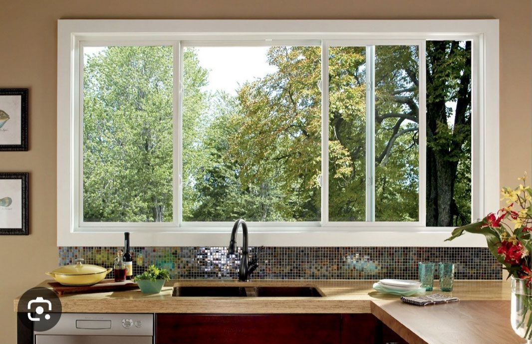 A kitchen with a large window and a sink