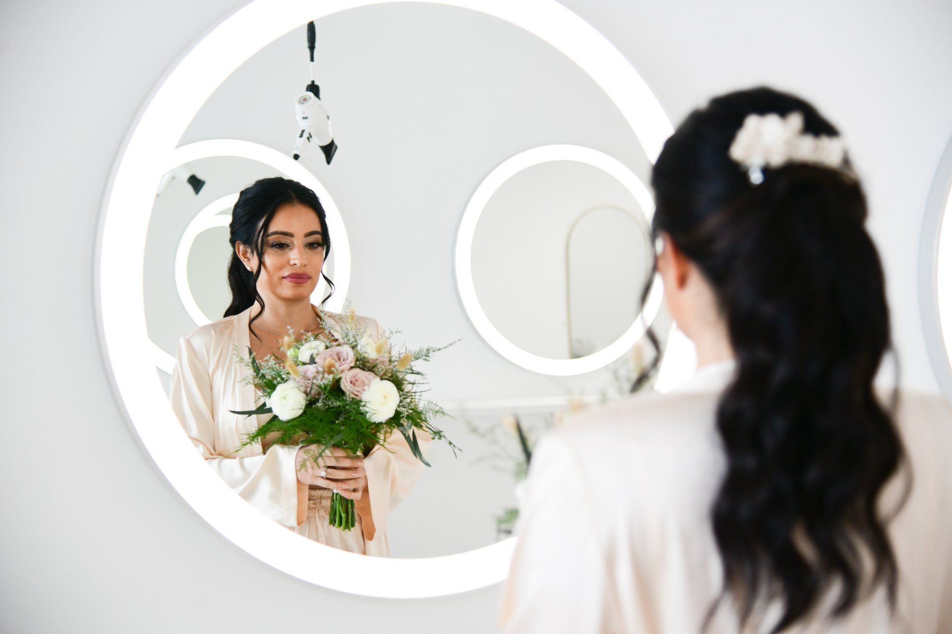 a woman is holding a bouquet of flowers and looking at herself in a mirror 