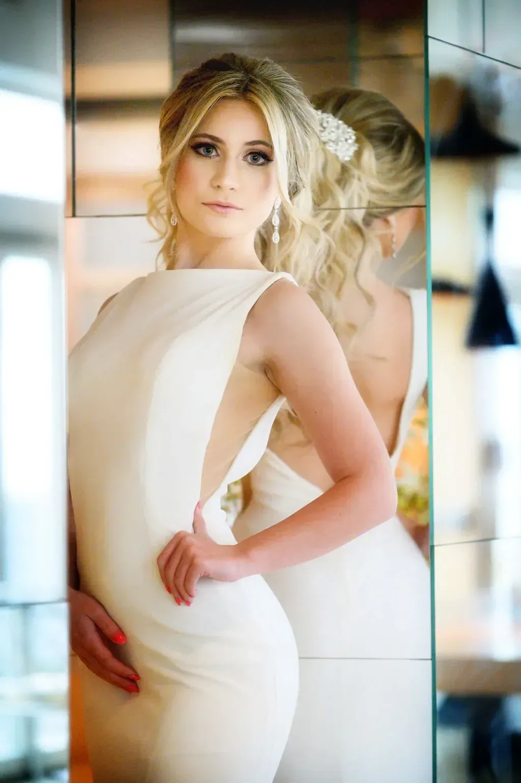 a woman in a white dress is standing in front of a mirror 